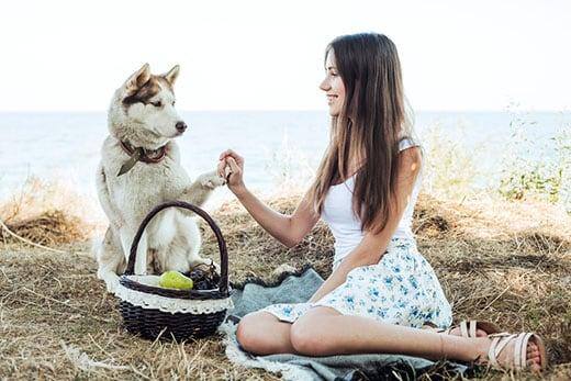 Mujer sosteniendo un  husky siberiano rojo